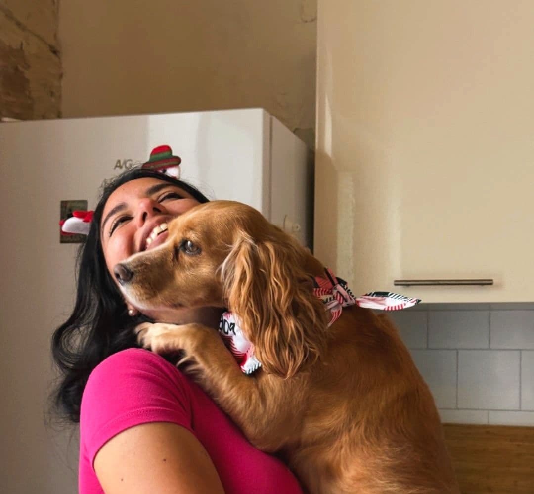 Angelica cradling a happy cocker spaniel in a warm Maltese kitchen